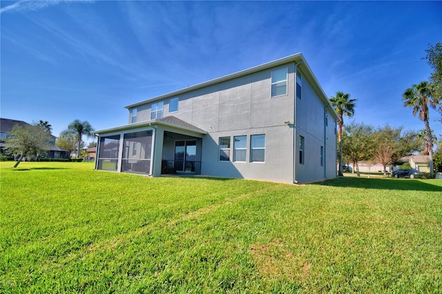 back of property featuring a sunroom and a lawn