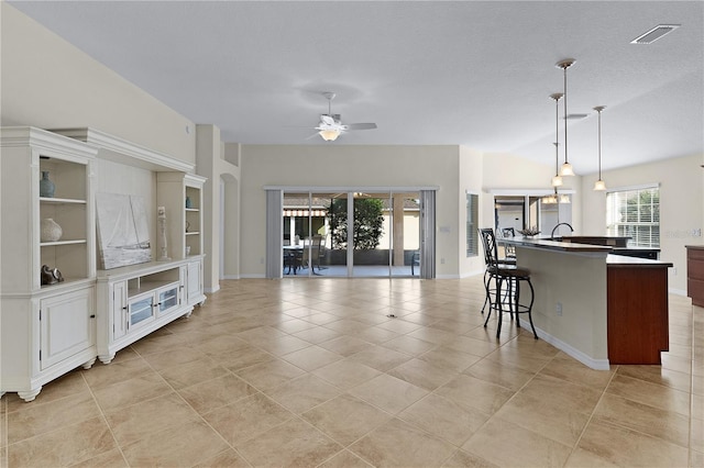 tiled living room featuring lofted ceiling, a textured ceiling, and ceiling fan