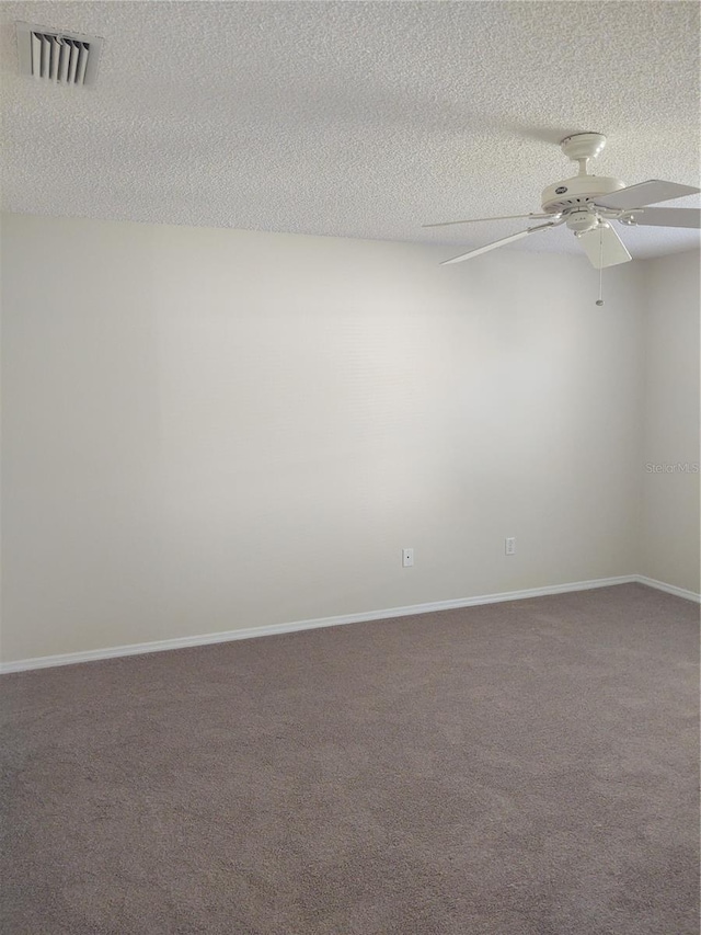 empty room with ceiling fan, carpet floors, and a textured ceiling