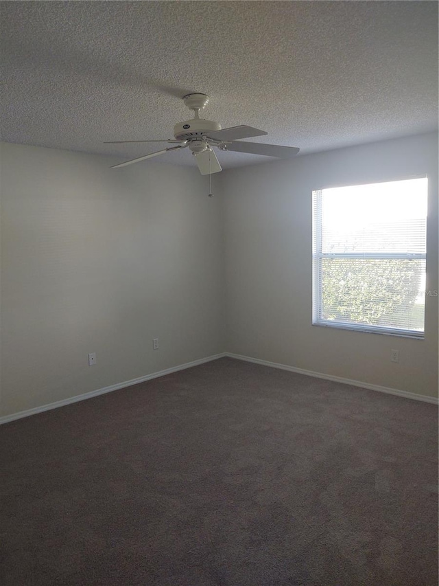 carpeted empty room featuring ceiling fan and a textured ceiling