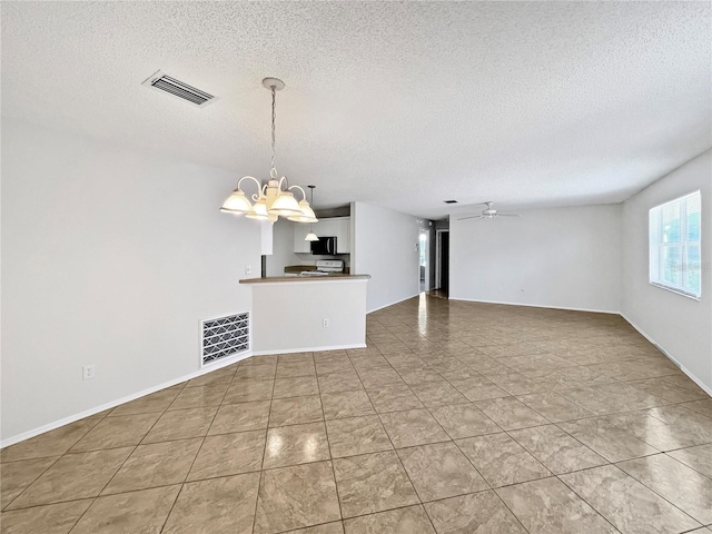 unfurnished living room featuring ceiling fan with notable chandelier and a textured ceiling