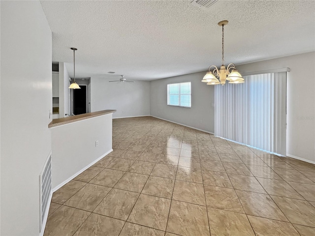 interior space with ceiling fan with notable chandelier, a textured ceiling, and light tile patterned flooring