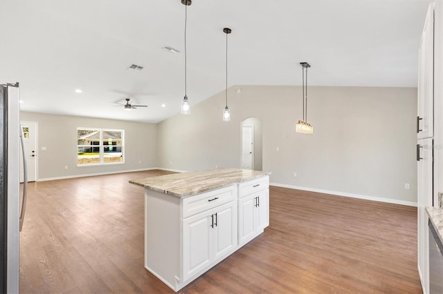 202 Shannon Ln, Lady Lake, FL 32159 - kitchen with stainless steel refrigerator, decorative light fixtures, light stone countertops, and white cabinets