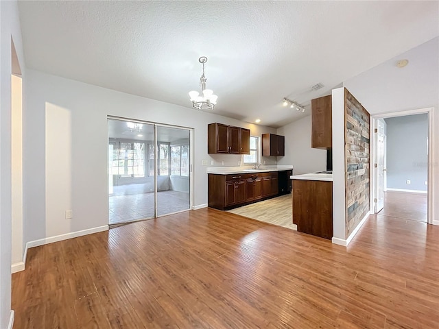 kitchen featuring an inviting chandelier, decorative light fixtures, and light hardwood / wood-style flooring