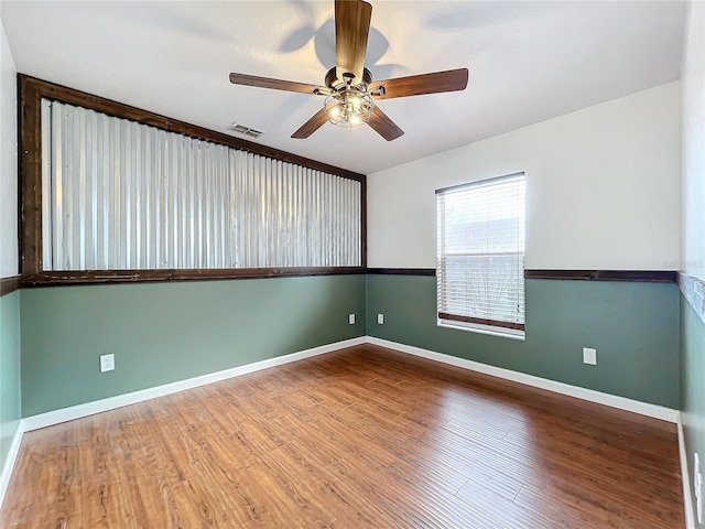 empty room with hardwood / wood-style flooring and ceiling fan