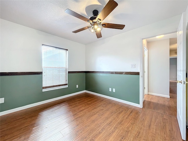 unfurnished room featuring a textured ceiling, wood-type flooring, and ceiling fan