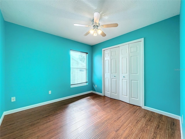 unfurnished bedroom featuring ceiling fan, dark wood-type flooring, a closet, and a textured ceiling