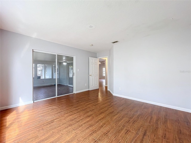 unfurnished bedroom featuring hardwood / wood-style flooring, a closet, and a textured ceiling