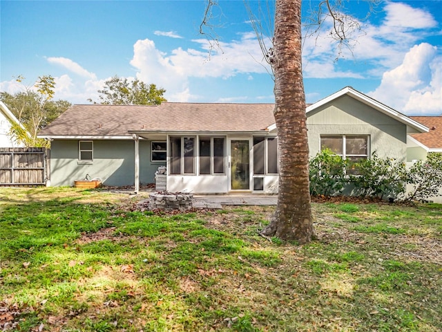 rear view of property with a sunroom and a yard