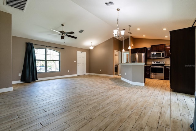 kitchen with appliances with stainless steel finishes, hanging light fixtures, dark brown cabinets, a center island, and light wood-type flooring