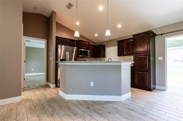 kitchen featuring stainless steel appliances, decorative light fixtures, an island with sink, and dark brown cabinets