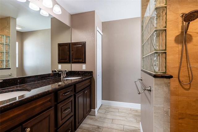 bathroom featuring tiled shower and vanity