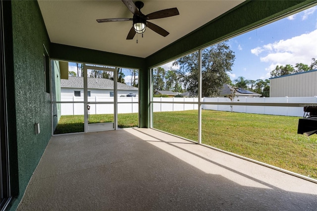 unfurnished sunroom featuring ceiling fan