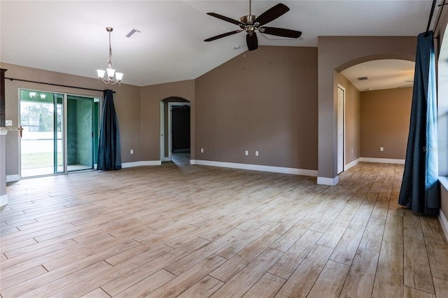 spare room featuring ceiling fan with notable chandelier, visible vents, vaulted ceiling, arched walkways, and light wood-style floors