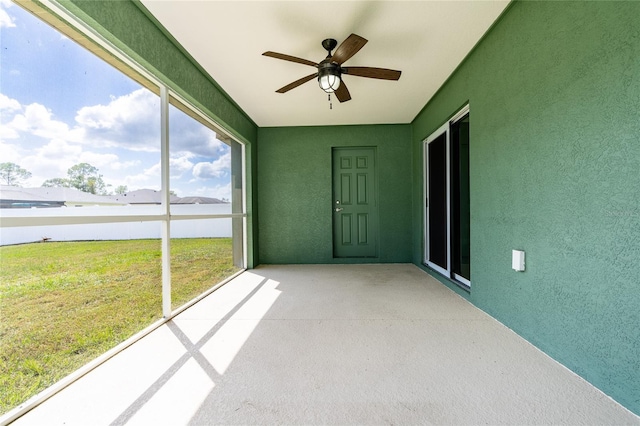 unfurnished sunroom featuring ceiling fan