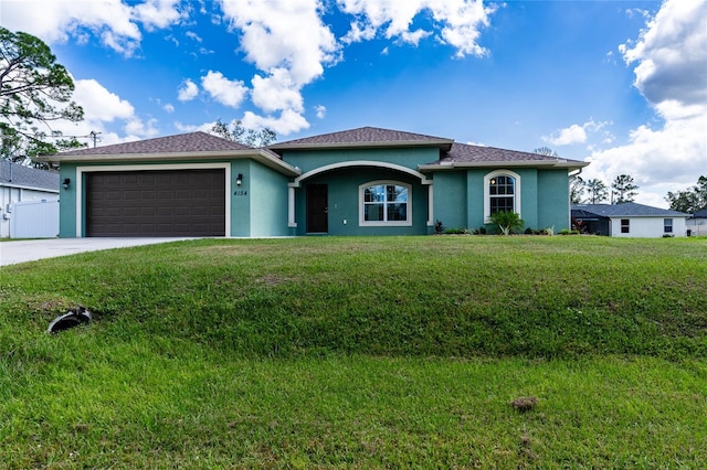 view of front facade with stucco siding, an attached garage, a front lawn, and driveway