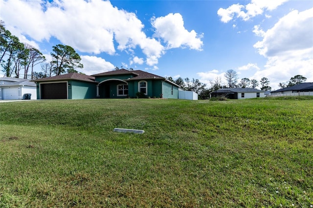 ranch-style house featuring stucco siding, an attached garage, and a front yard