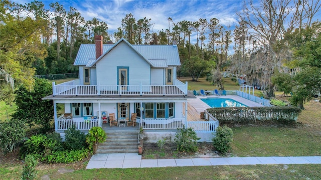 view of front of home with a pool side deck, a front yard, and a balcony