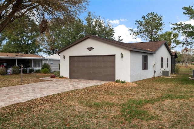 view of side of home featuring a garage, a yard, and central air condition unit