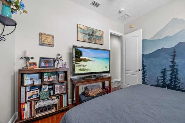 bedroom with dark hardwood / wood-style flooring and a textured ceiling