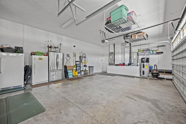 garage featuring water heater, white fridge, a garage door opener, and stainless steel refrigerator