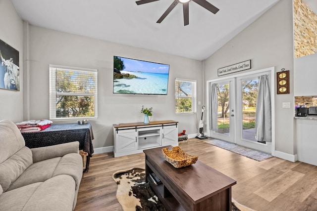 living room with vaulted ceiling, ceiling fan, light hardwood / wood-style floors, and french doors