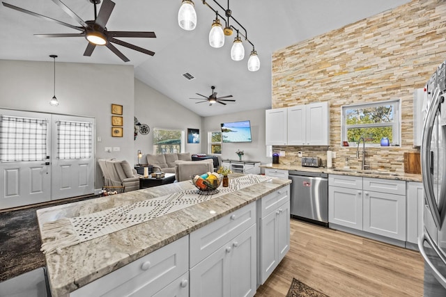 kitchen featuring stainless steel appliances, light stone countertops, and white cabinets