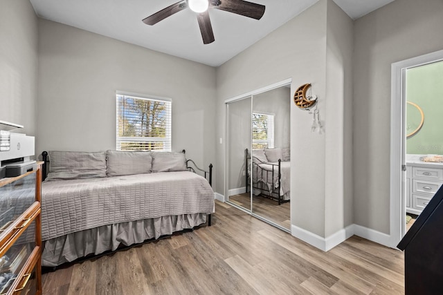 bedroom featuring ceiling fan, light hardwood / wood-style floors, and a closet