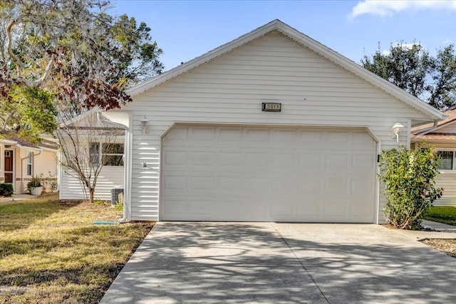 view of front of home with a garage, central AC, and an outbuilding