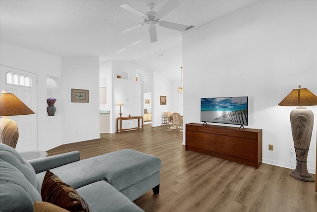 living room featuring lofted ceiling, hardwood / wood-style flooring, and ceiling fan