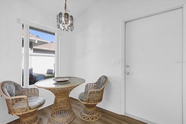 dining area featuring hardwood / wood-style flooring and an inviting chandelier