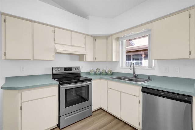 kitchen with premium range hood, sink, light wood-type flooring, stainless steel appliances, and cream cabinetry