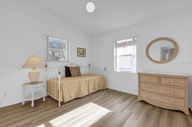 bedroom featuring hardwood / wood-style flooring and vaulted ceiling