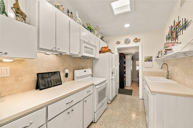 kitchen featuring a sink, white appliances, light countertops, and white cabinetry