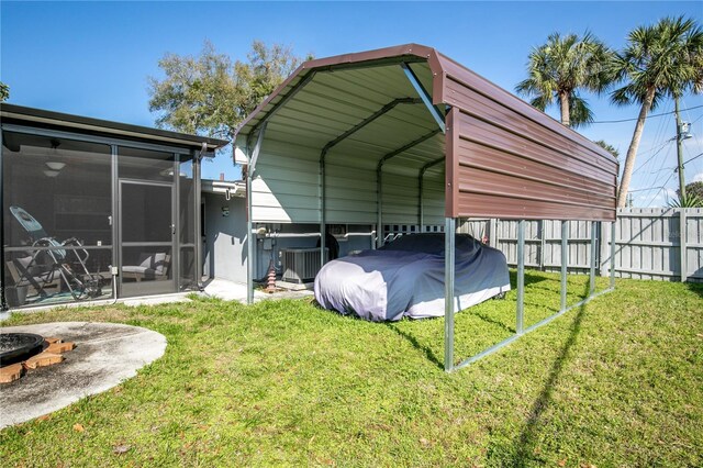 view of outbuilding with cooling unit, a sunroom, a detached carport, and fence