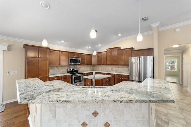 kitchen featuring stainless steel appliances, hanging light fixtures, and a large island