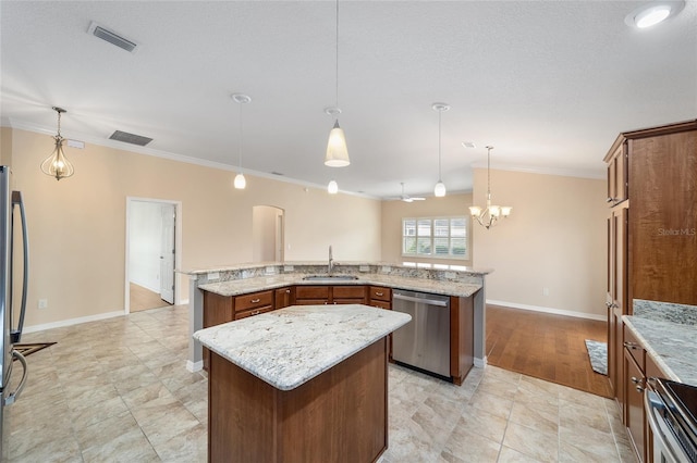 kitchen featuring pendant lighting, sink, stainless steel appliances, and a kitchen island