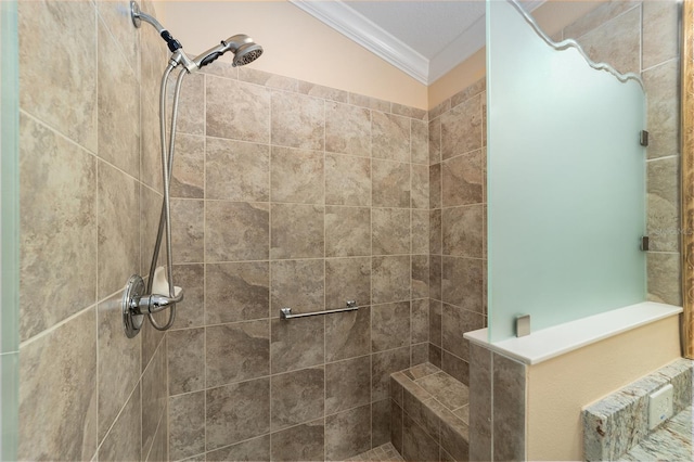 bathroom with a tile shower and ornamental molding