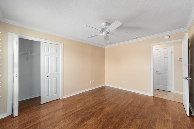 unfurnished bedroom featuring crown molding, hardwood / wood-style floors, a closet, and a textured ceiling