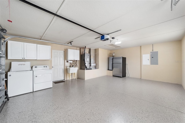 garage featuring a garage door opener, heating unit, stainless steel fridge, electric panel, and independent washer and dryer