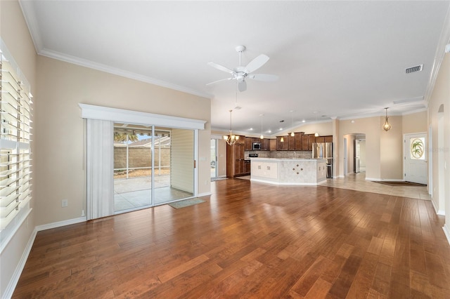 unfurnished living room featuring hardwood / wood-style flooring, ornamental molding, and ceiling fan with notable chandelier