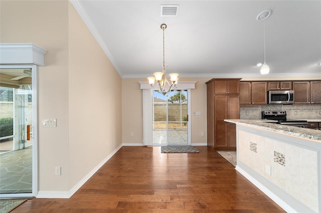 kitchen with dark wood-type flooring, hanging light fixtures, backsplash, stainless steel appliances, and ornamental molding