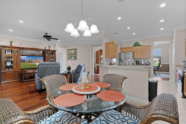 13914 SE 96th Cir, Summerfield, FL 34491 - dining room with ornamental molding, sink, light hardwood / wood-style floors, and ceiling fan with notable chandelier