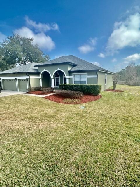 view of front of house with a garage and a front lawn