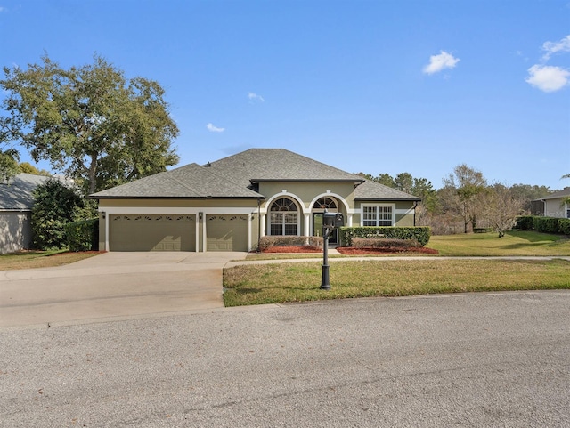 view of front of house featuring a garage and a front lawn