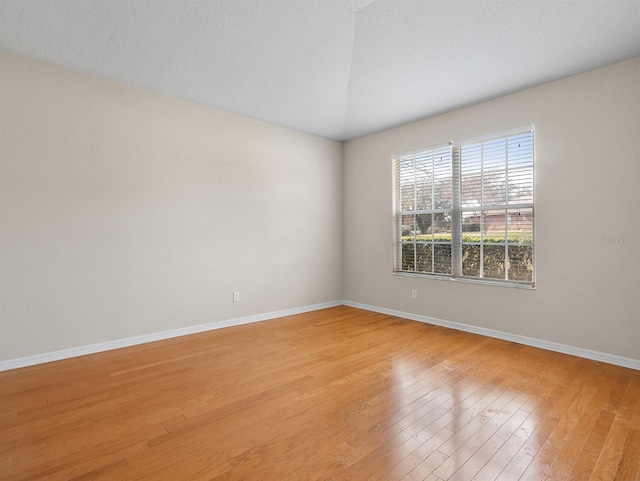 empty room featuring a textured ceiling and light wood-type flooring