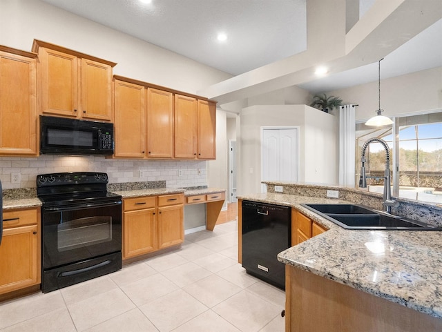 kitchen featuring tasteful backsplash, sink, hanging light fixtures, light stone counters, and black appliances