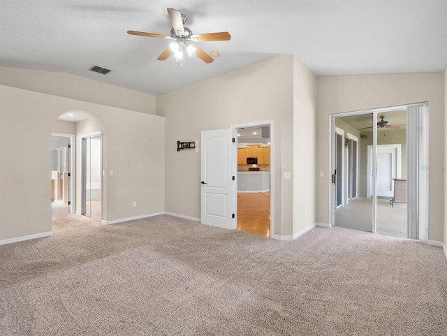 unfurnished bedroom featuring vaulted ceiling, light colored carpet, and ceiling fan