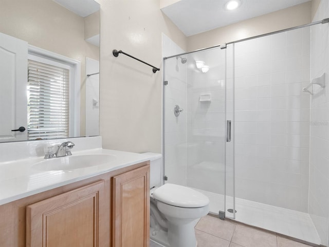 bathroom featuring walk in shower, vanity, toilet, and tile patterned flooring