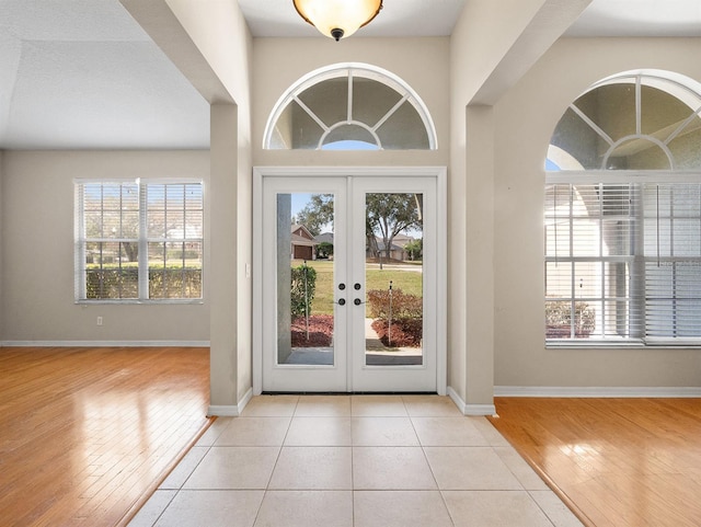 foyer with light hardwood / wood-style floors and french doors